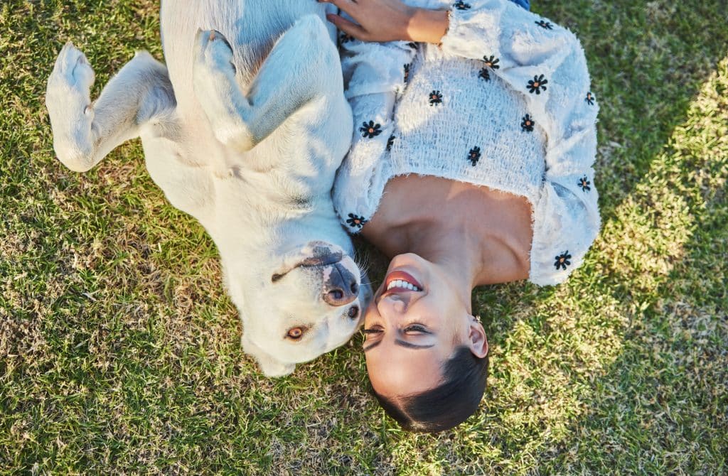 Happy, woman and dog relax on grass